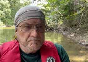 Man in a life jacket on a river.