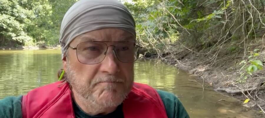 Man in a life jacket on a river.