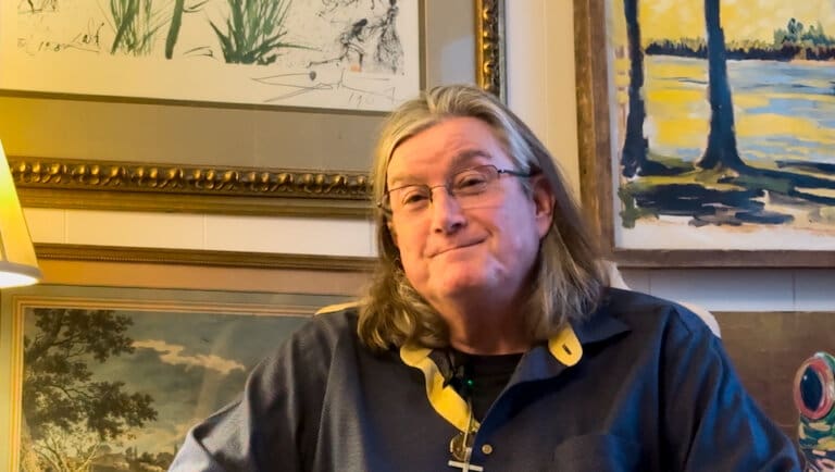 Man sitting in front of paintings
