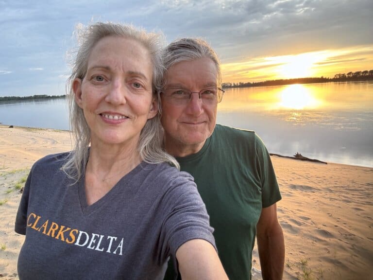 Happy pair enjoying lakeside sunset view