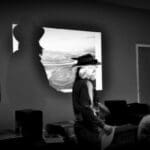 Two people in hats standing in a room.