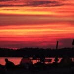 Silhouettes at sunset by a lake.