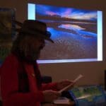 Man in a hat looking at a presentation.
