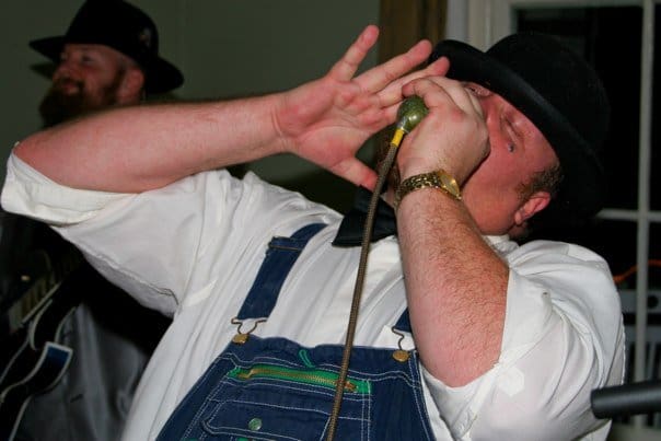 Harmonica player performing passionately on stage