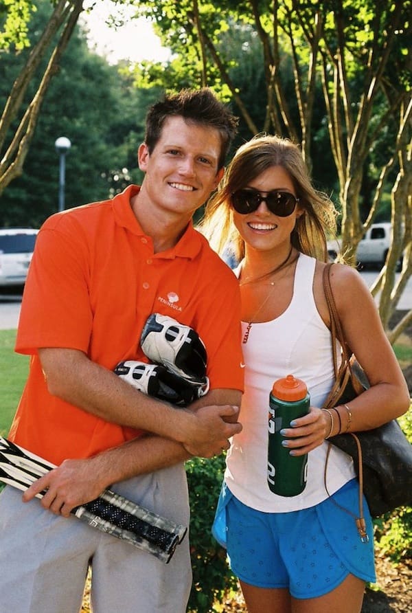 Couple holding tennis equipment