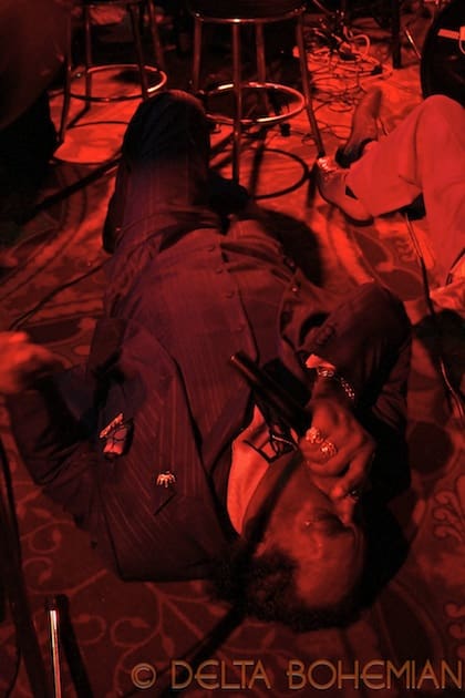 Musician performing on a dimly lit stage.