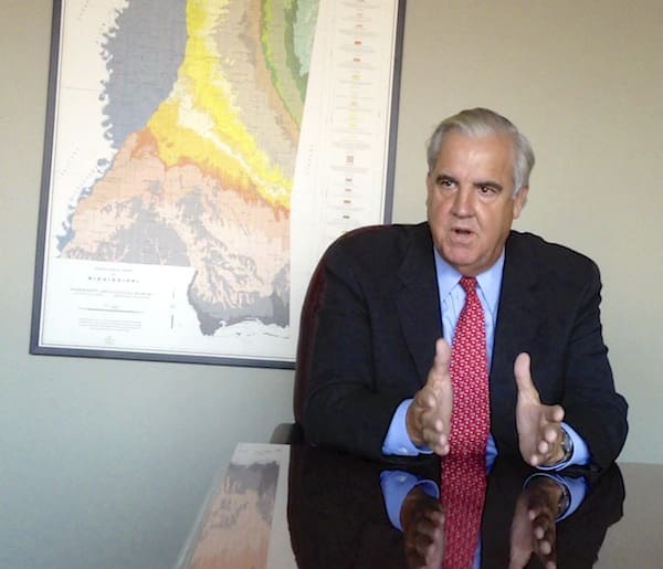 Man speaking at a desk with map