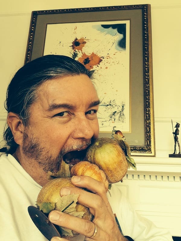 Person biting a cluster of pears.