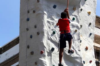 Boy scaling climbing wall