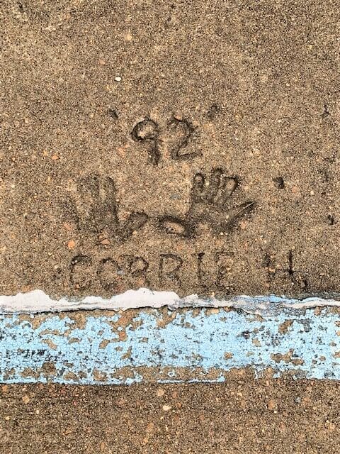 Concrete handprints and writing near blue line