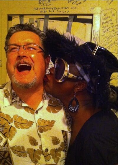 Man laughing with woman in costume