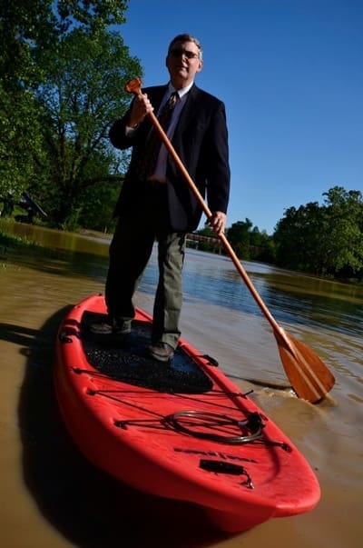 Businessman paddleboarding on red board