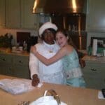 Two women smiling in a kitchen.