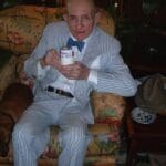 Man in striped suit holds a can.