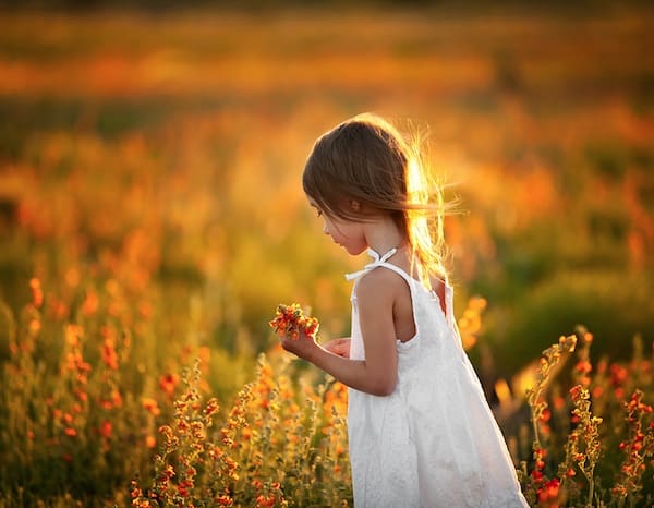 Girl in white dress among wildflowers
