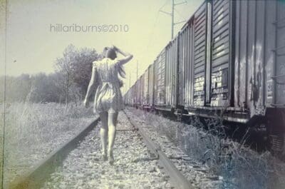 Woman walking along train tracks