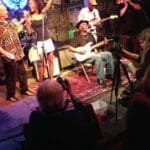 A band playing live on stage with a photographer