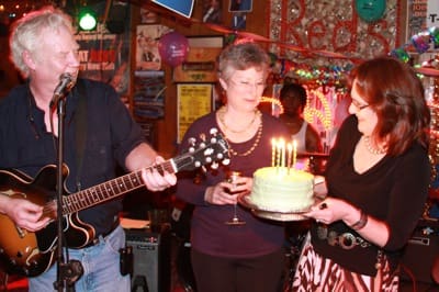 Woman presenting birthday cake with candles