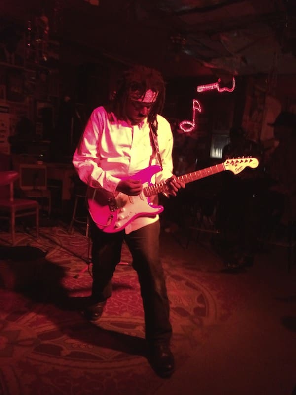 Guitarist playing under red lighting