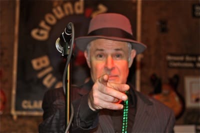 Man in hat pointing at camera