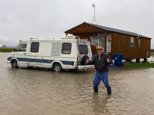 Person giving thumbs up in waterlogged area