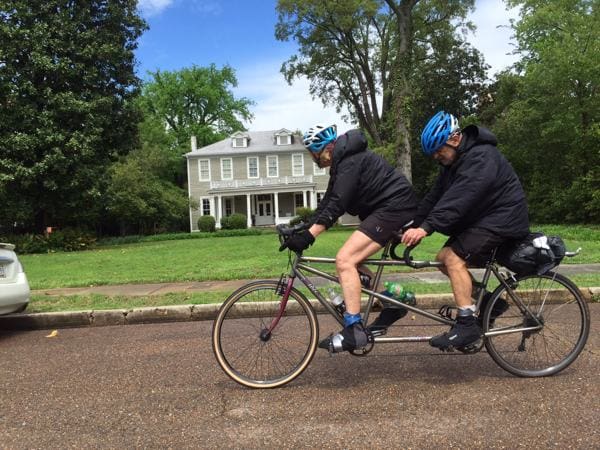 Tandem bike ride near suburban house