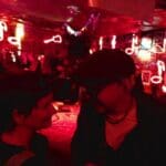Two people in a dimly lit room with music notes.