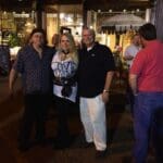 Four people stand in front of a store.
