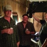 Three men with beer in a room.
