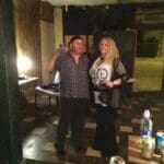 Couple poses with drinks in a bar.