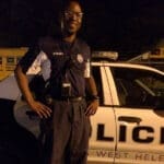 Police officer standing next to car.