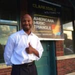 Man smiling in front of Americana Music Triangle sign.