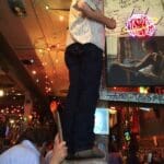 Man on a ladder painting a wall.