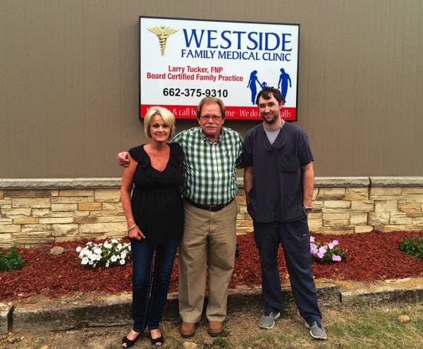 Three people in front of medical clinic