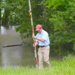 Delta Bohemian Lil John McKee measuring next to the Mighty Mississippi River on his land. Photo by The Delta Bohemian