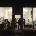 People gathered for an art exhibit at night.