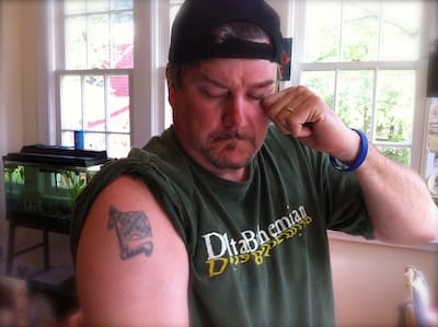 Man in cap showing arm tattoo