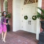 Woman in pink dress walking by a door.