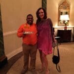Two people smiling, one holding champagne.