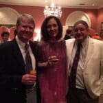 Three people smiling at a formal event.
