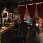 People gathered in a dimly lit room with desserts.