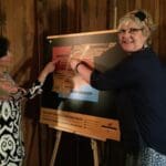 Two women pointing at a map of the American South.
