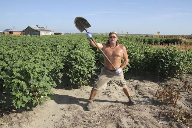 Shirtless farmer with shovel