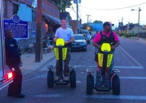 Two men riding police-marked segways.