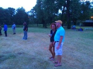 Couple standing together in a field.