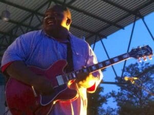 Man playing electric guitar on stage.