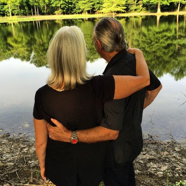 Couple embracing by a serene lake