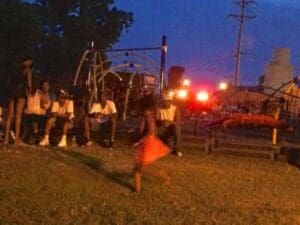 Group of people at a playground at dusk.