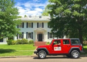 Red Jeep parked in front of a house.