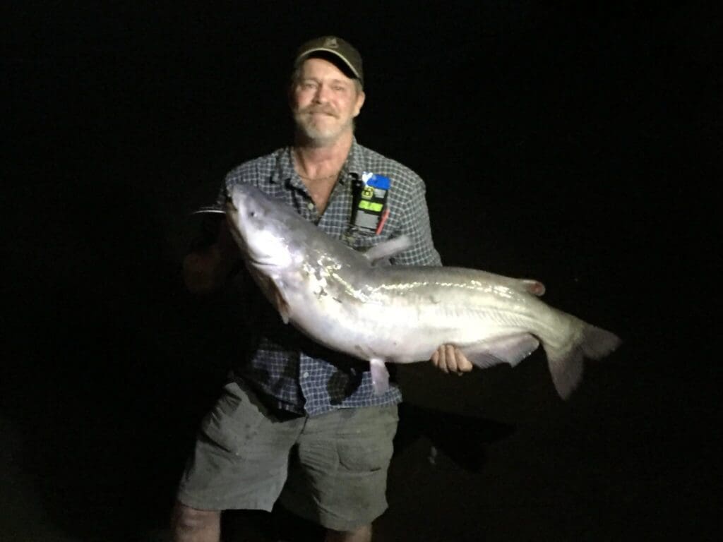 Wild Bill Briscoe shows his huge blue catfish to Dana Starkell and his group traveling the Mississippi River.